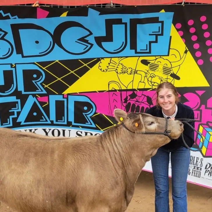 Sydnie with a show steer in front of the junior fair banner